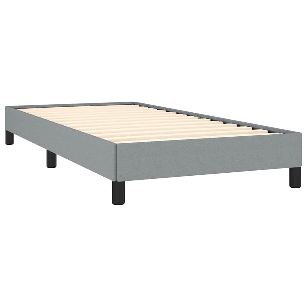 Grey fabric twin bed frame with white mattress and black legs
