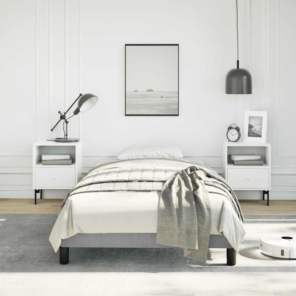 Modern grey upholstered twin bed frame with white bedside tables and a minimalist aesthetic