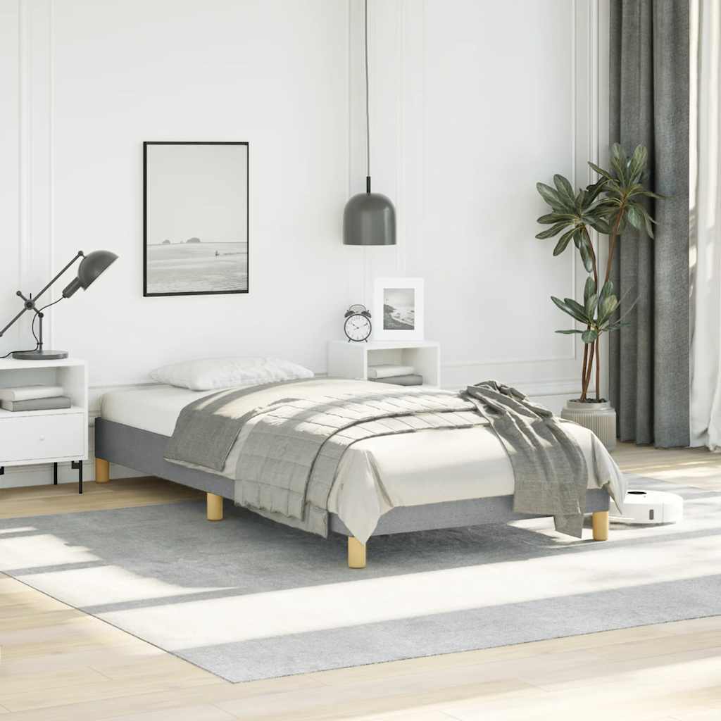 Gray fabric upholstered twin bed frame with wooden slats and gold legs