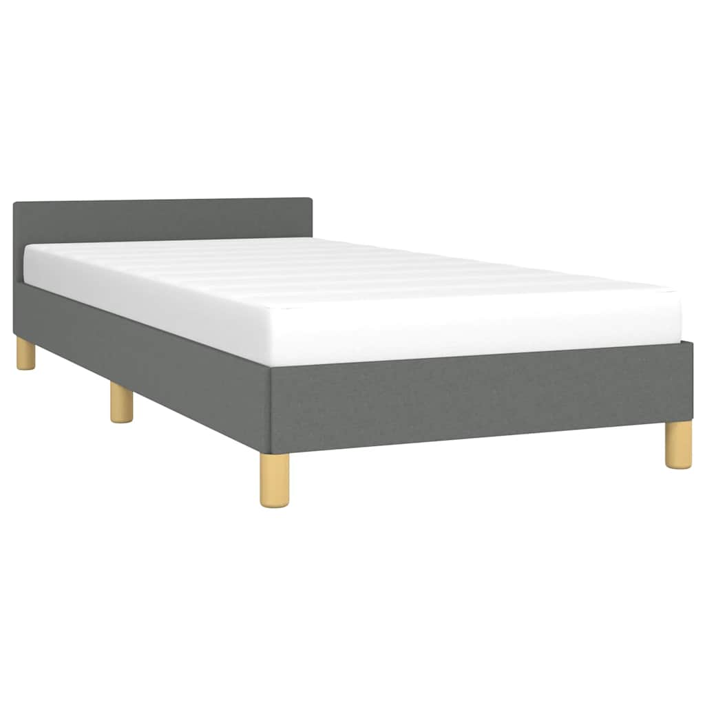 Grey upholstered twin bed frame with white mattress and wooden legs
