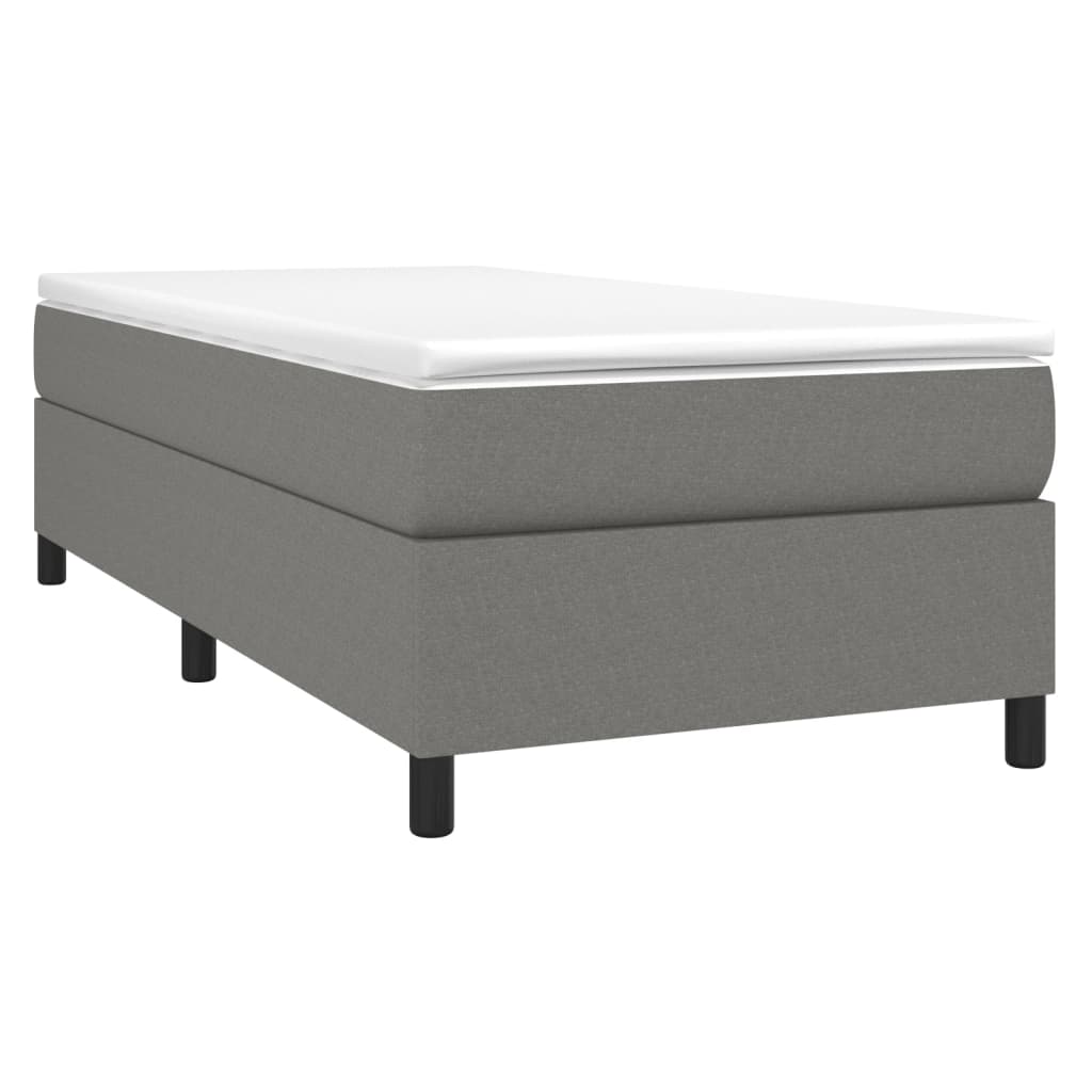 Grey upholstered divan bed base with white mattress topper and black legs