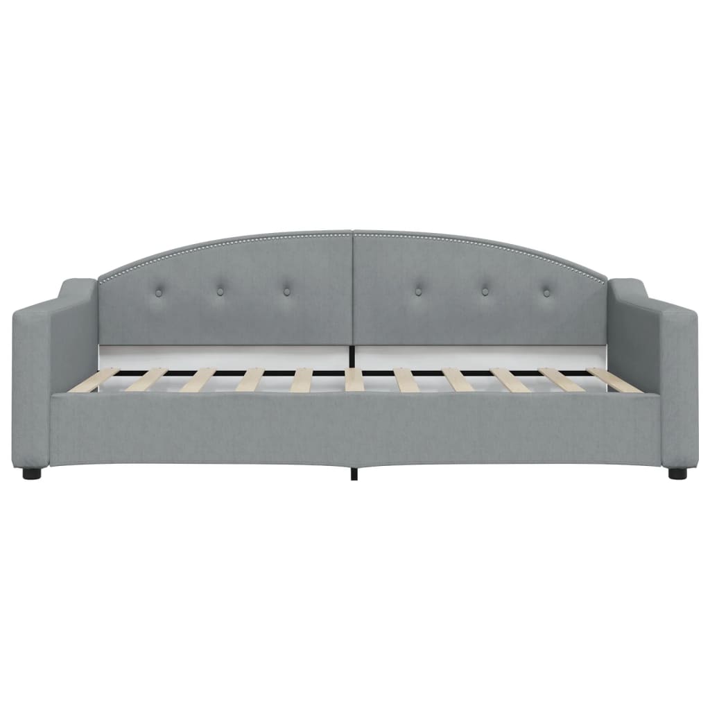 Grey upholstered daybed with tufted back and silver nailhead trim