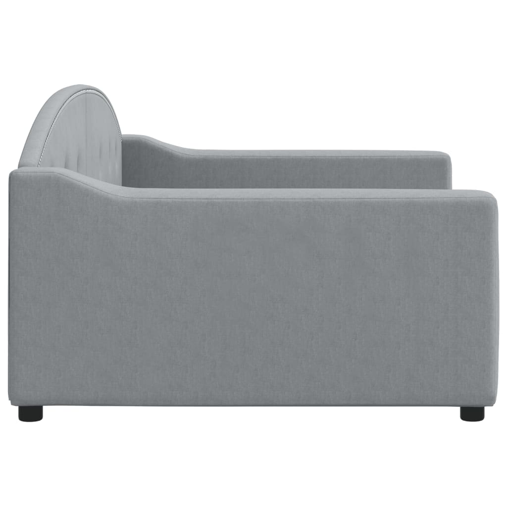 Grey upholstered daybed with tufted back and silver nailhead trim