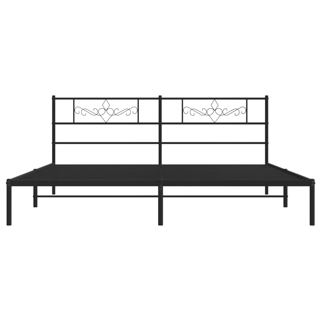 Dark grey metal bed frame with ornamental headboard detail and black and white patterned bedding
