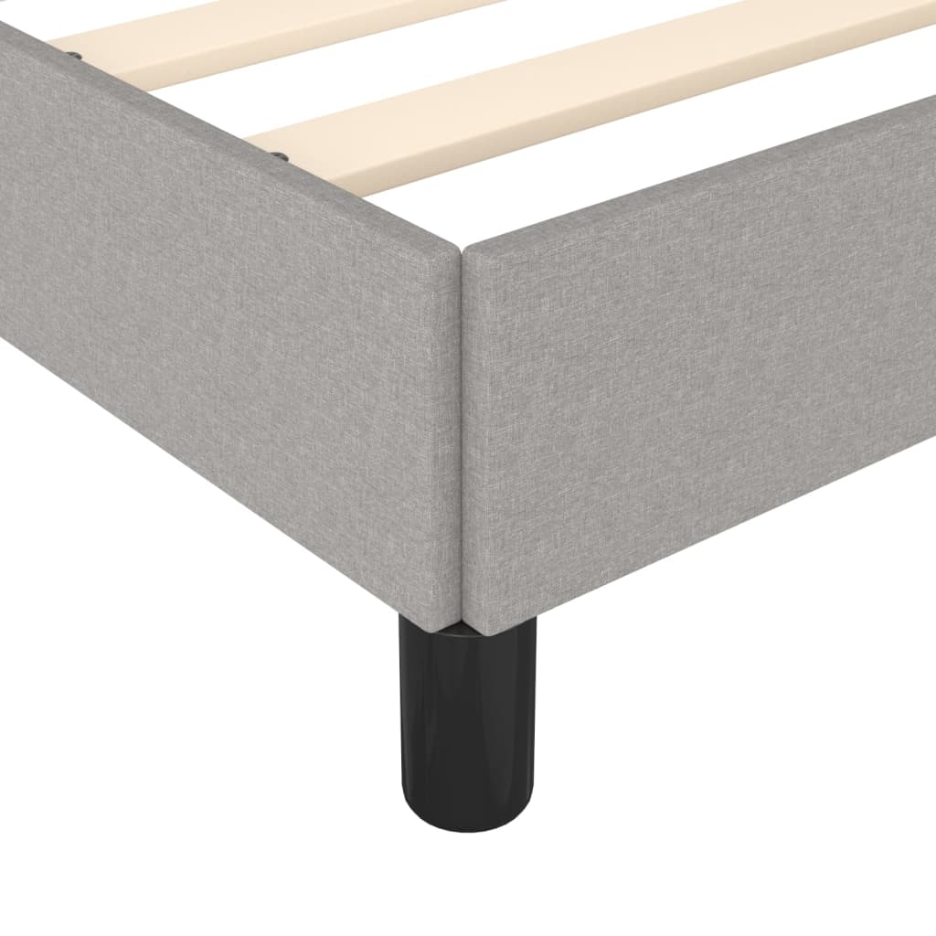 Grey upholstered twin bed frame with wooden slats and black legs