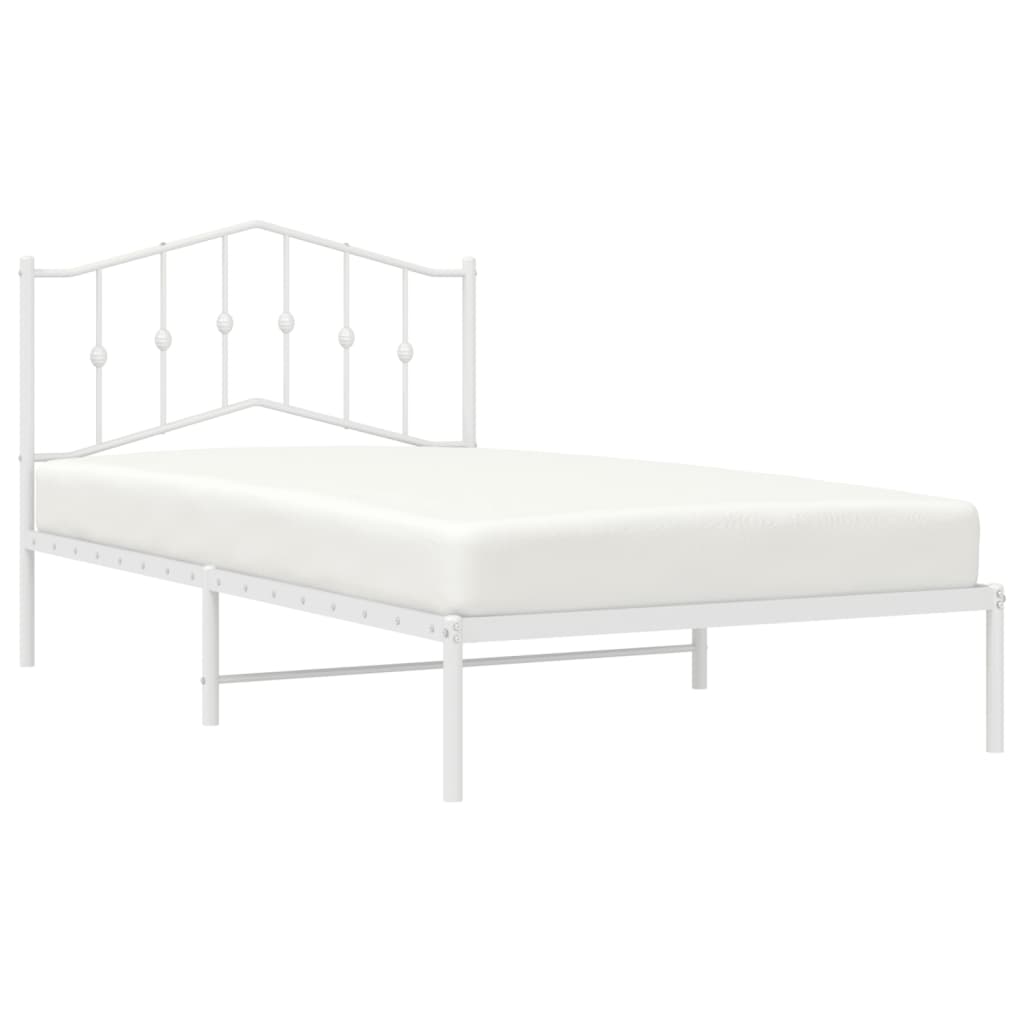 White metal twin bed frame with decorative headboard and mattress