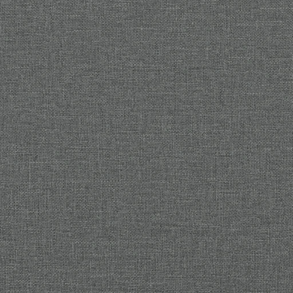 Closeup of a grey upholstered bed frame with a black cylindrical leg and wooden slat support
