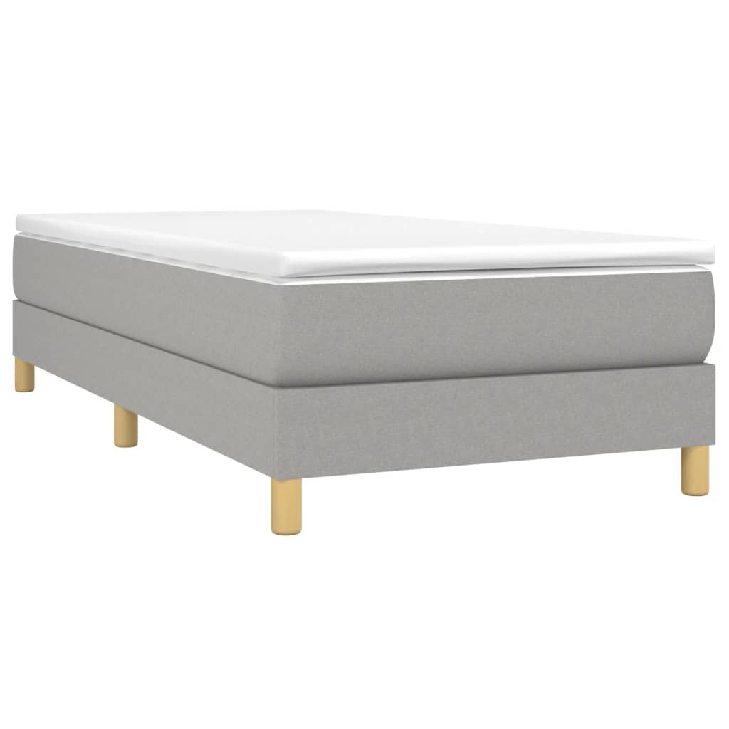 Upholstered grey divan bed with white mattress and wooden legs