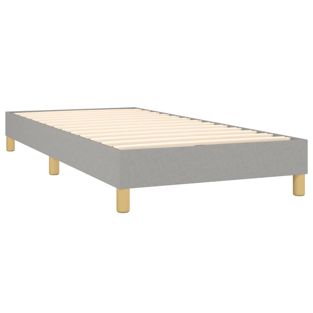 Gray upholstered bed frame with white mattress and wooden legs