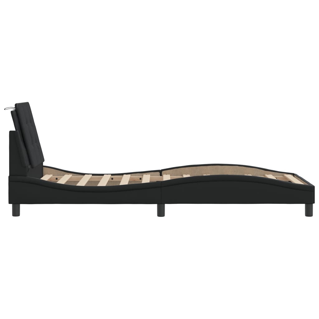 Black faux leather platform bed with tufted headboard and wood slats