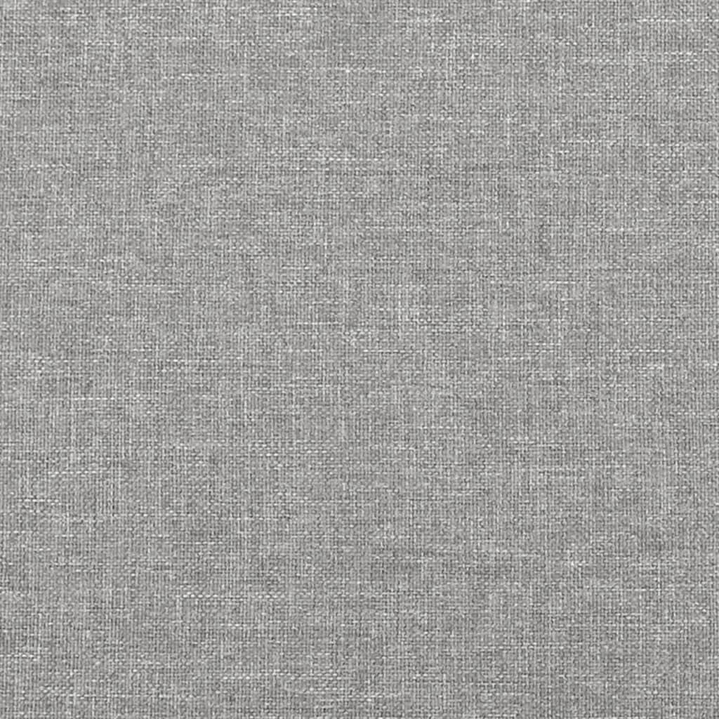 Closeup of a grey upholstered bed frame with wooden slats and black legs