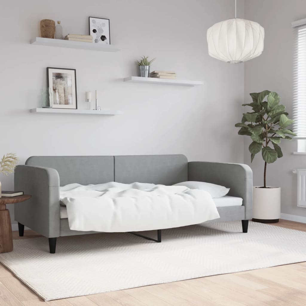 Grey upholstered sofa bed with white bedding