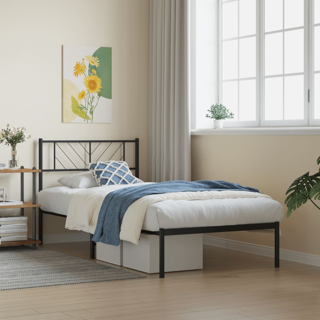 Black metal twin bed frame with patterned bedding and mountain art above