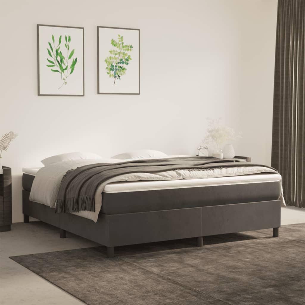 Dark gray upholstered divan bed with white mattress and charcoal throw