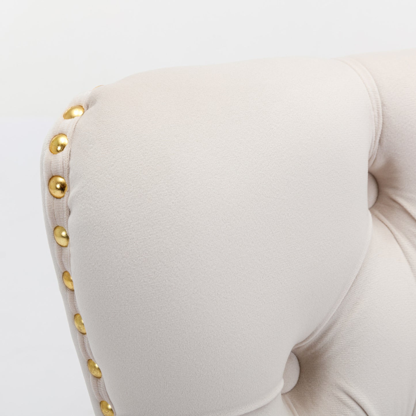 Cream velvet armchair detail with gold stud accents