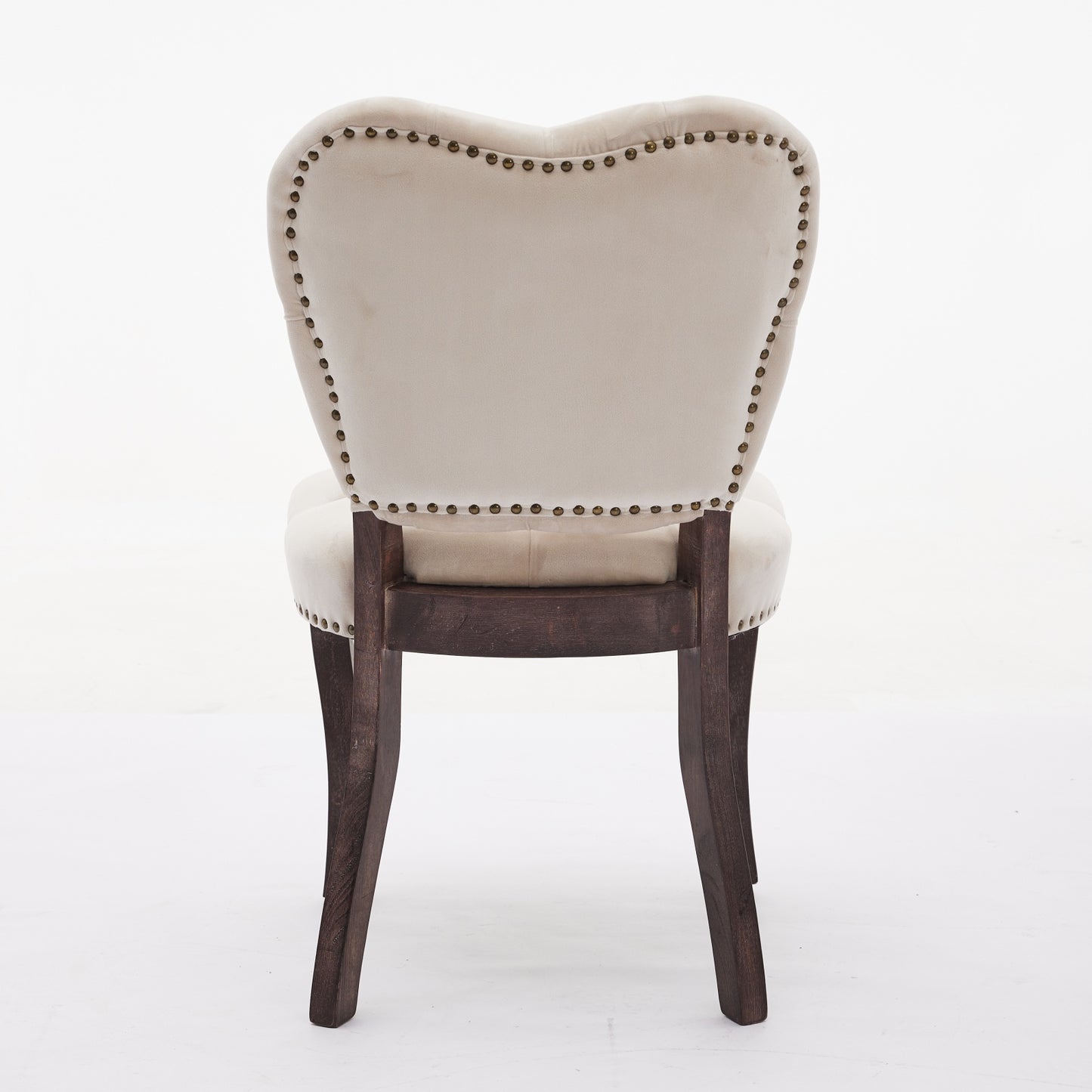 Cream velvet armchair with decorative brass nailhead trim and dark wood legs
