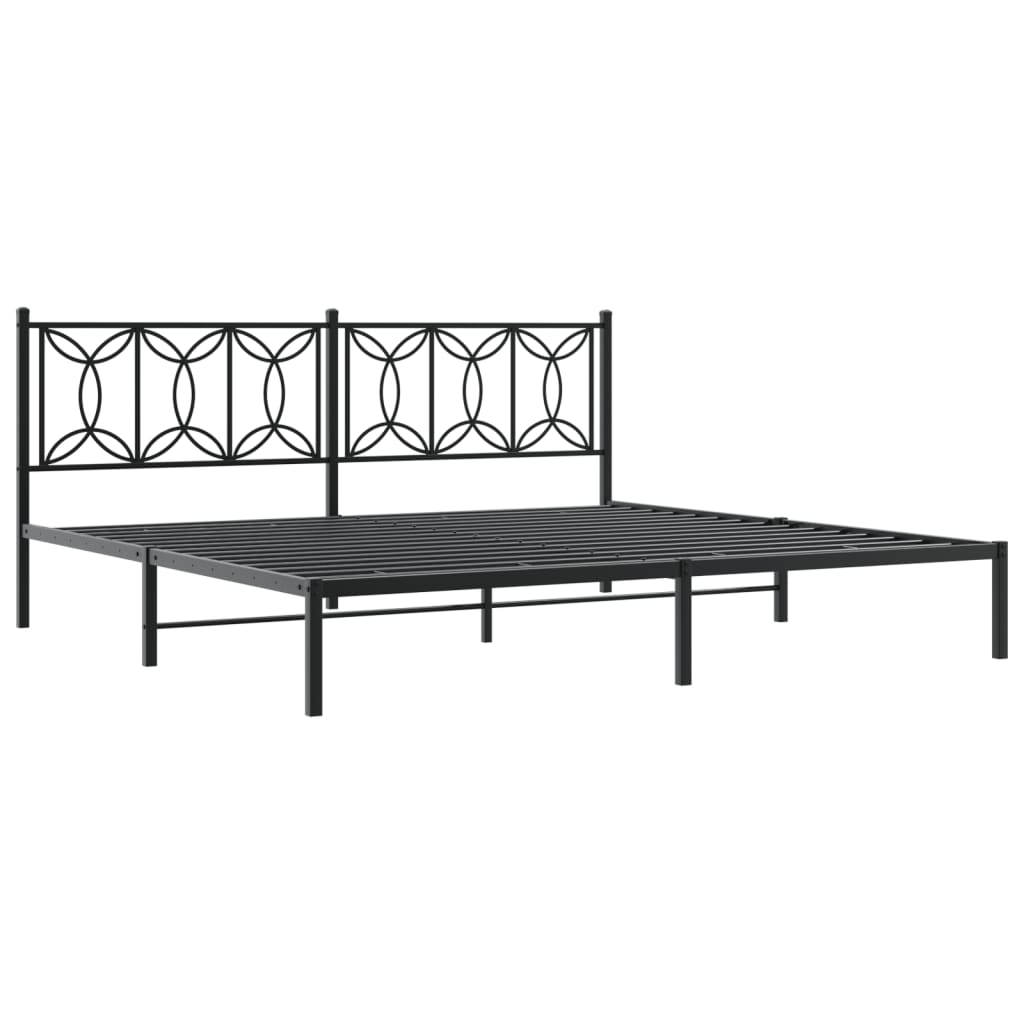 Black metal bed frame with ornate headboard and grey bedding