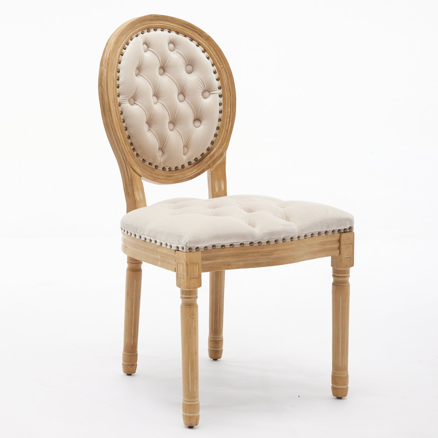 Tufted cream linen accent chair with distressed wood frame and brass nailhead trim