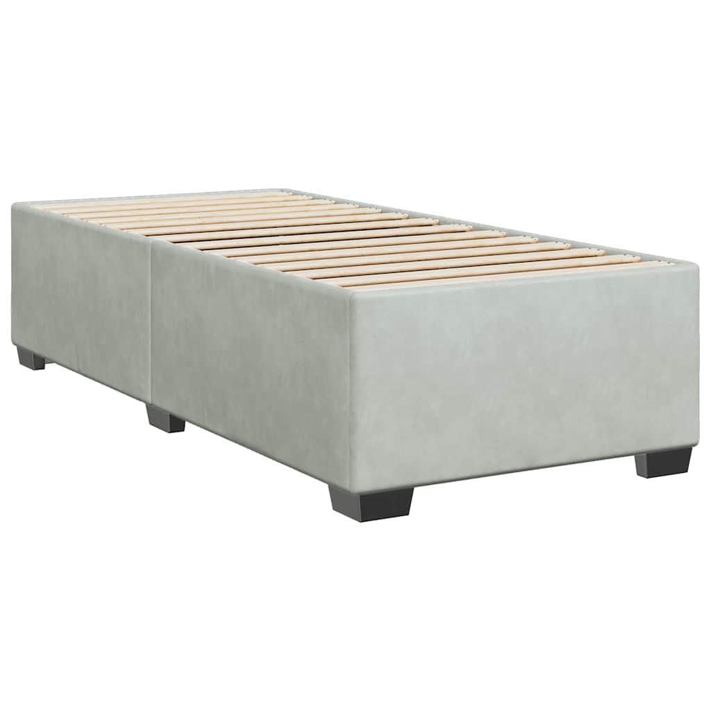 Light grey divan bed with white linen on a textured mattress