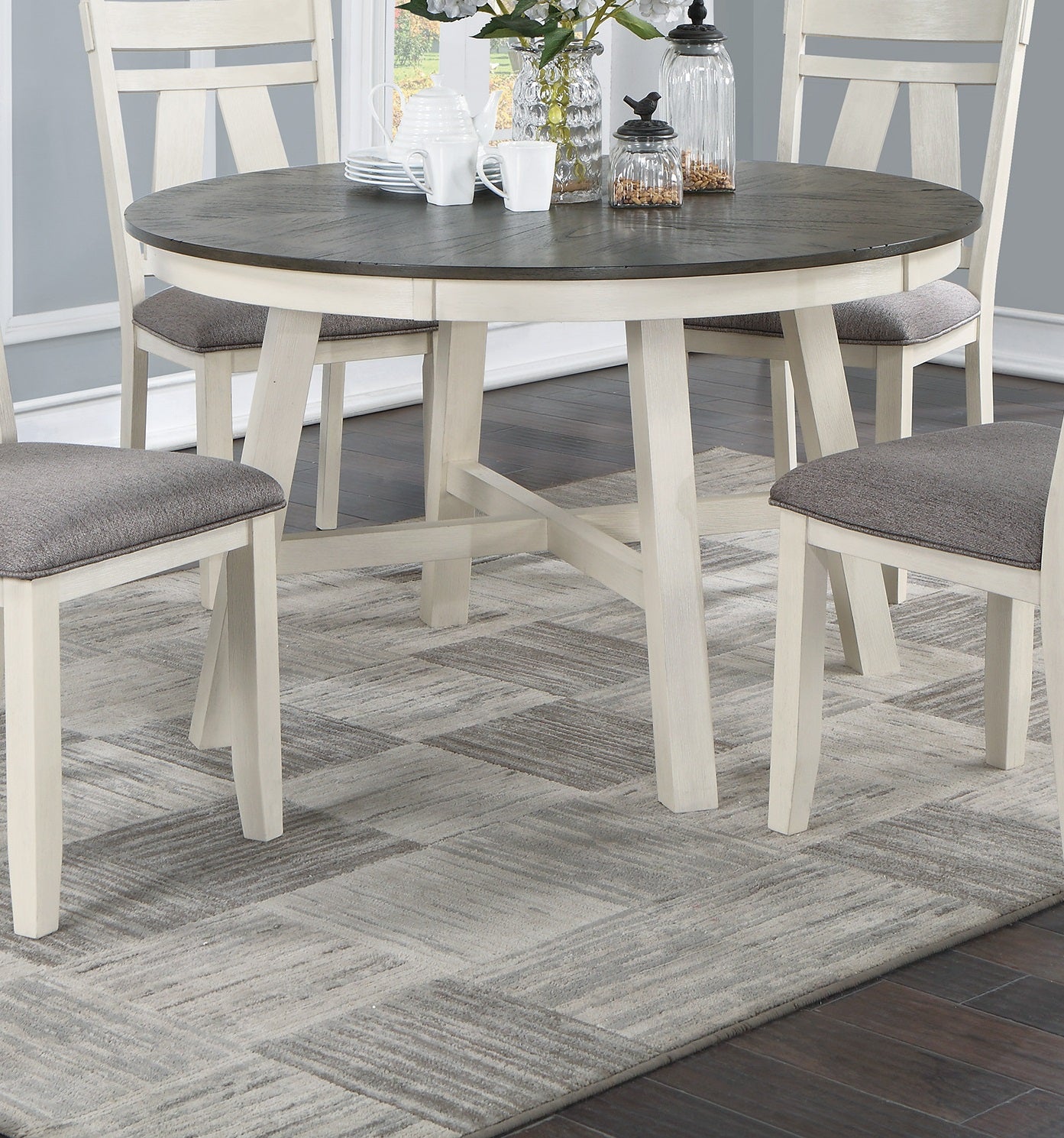 Round dining table with dark wood top and distressed white pedestal base