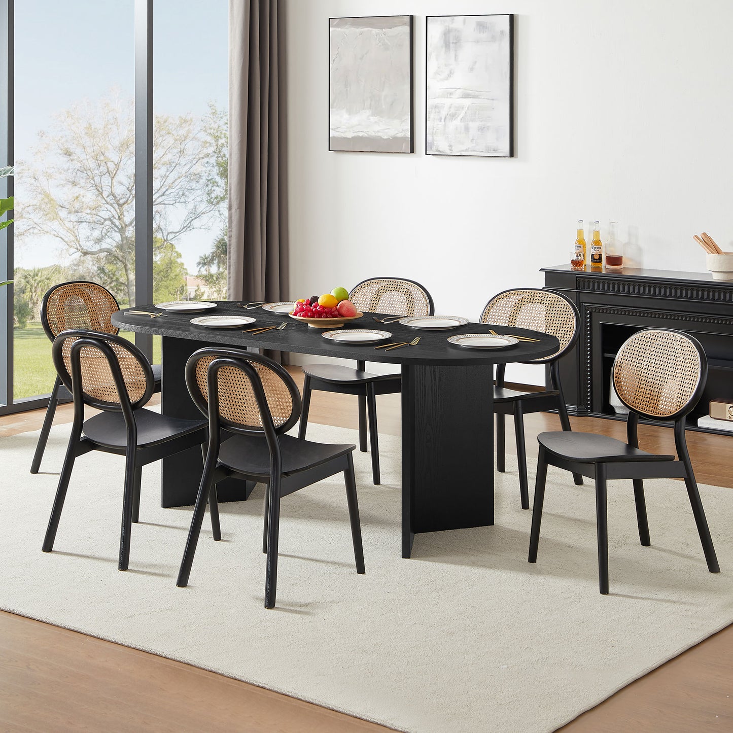 Black oval dining table with canebacked chairs