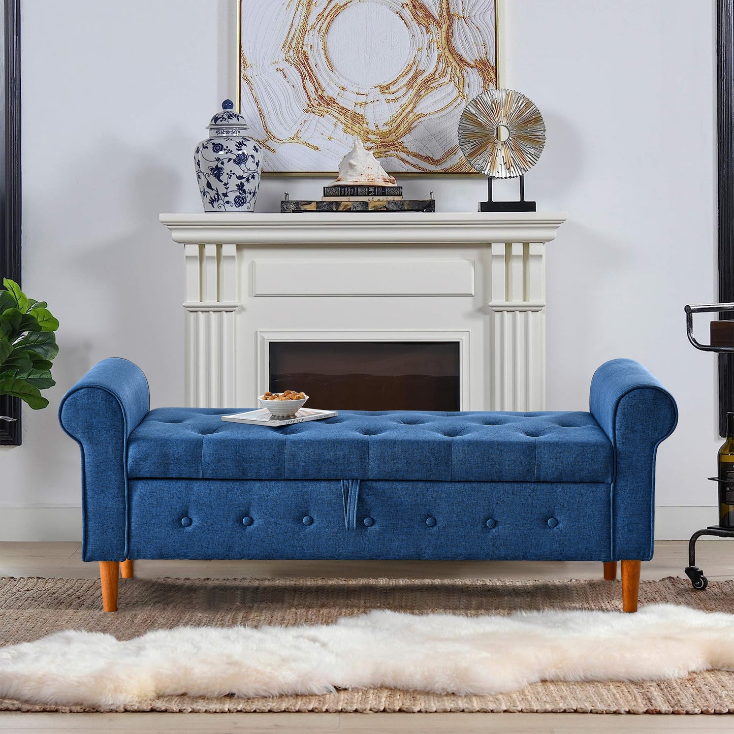 Tufted blue fabric storage bench with scroll arms and wooden legs