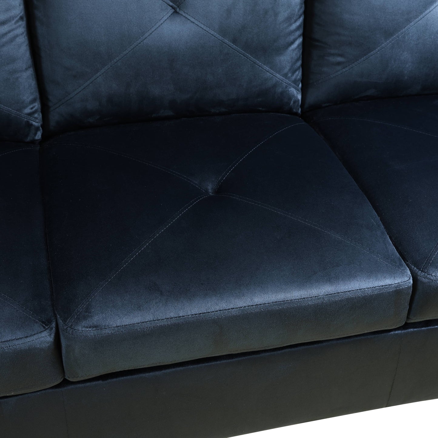 Black tufted faux leather sofa section with diamond stitching on seat cushions