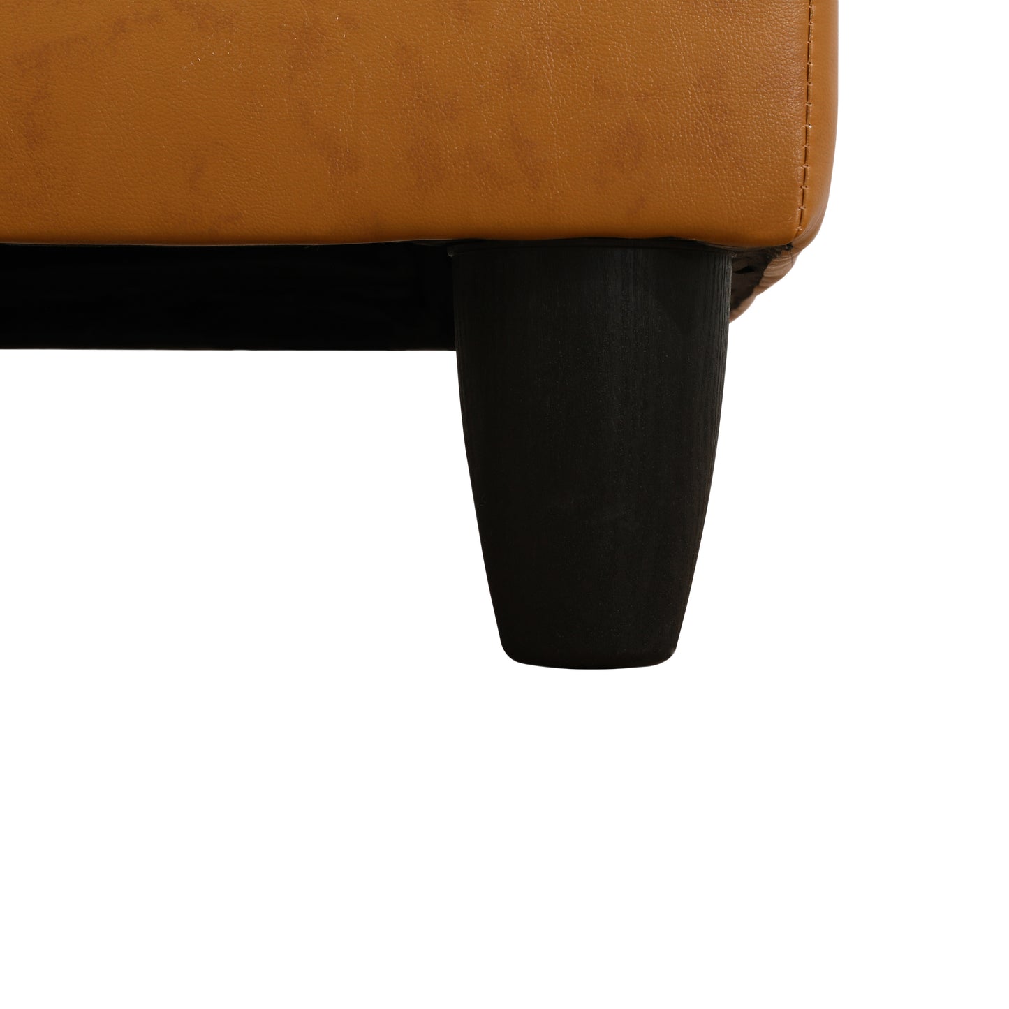 Tan leather armchair detail with dark wood leg