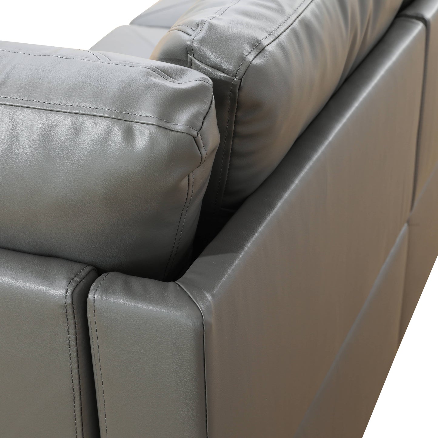 Closeup of a plush gray leather sofa armrest with intricate stitching details