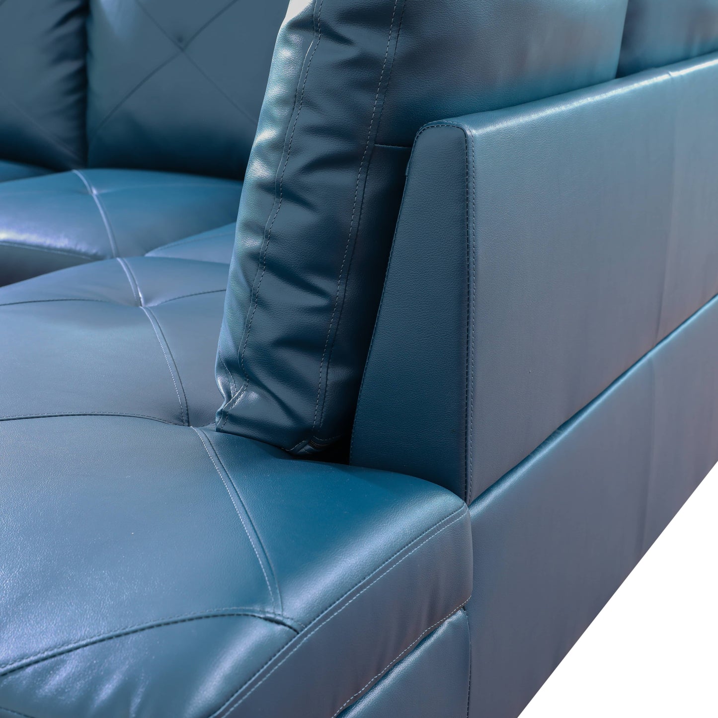Dark teal leather sofa detail with tufted cushions and stitched seams