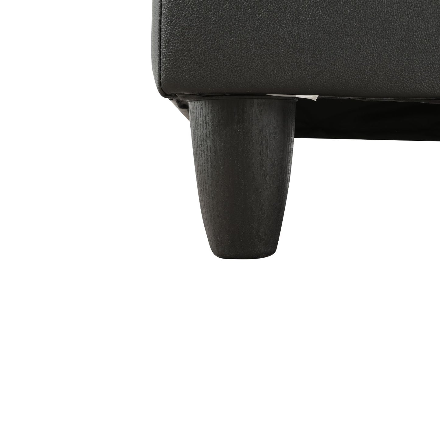 Black faux leather sofa corner with a dark wood tapered leg