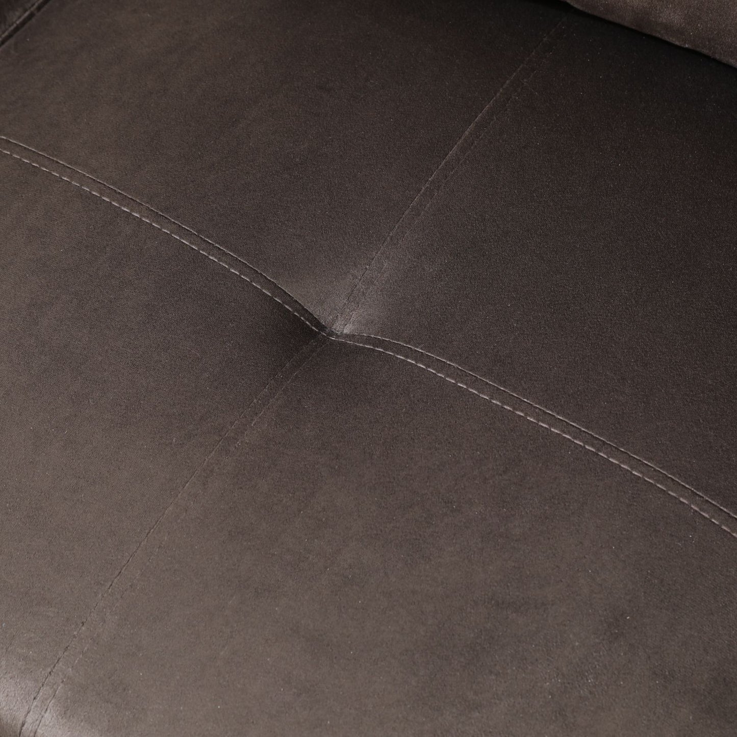 Closeup of plush brown faux leather sofa fabric with decorative stitching