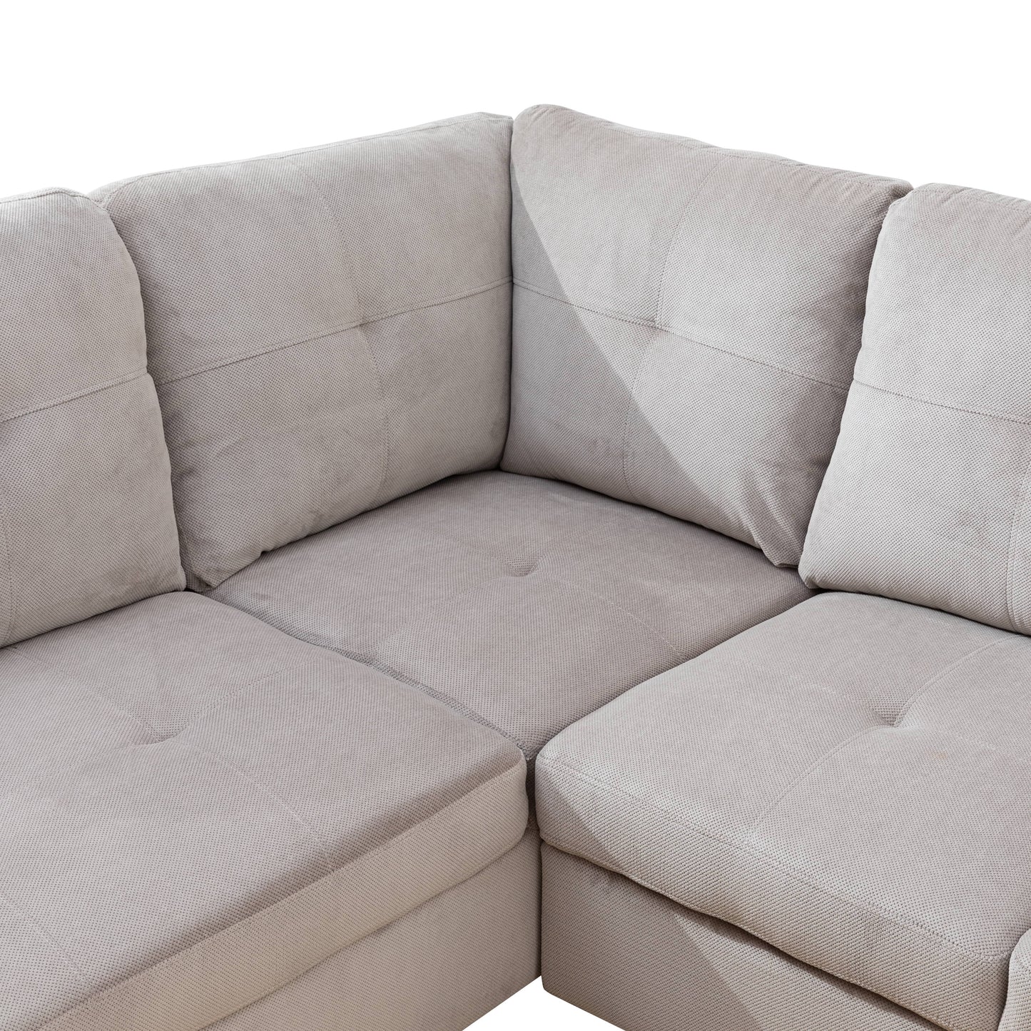 Light beige fabric sectional sofa with tufted cushions and textured upholstery