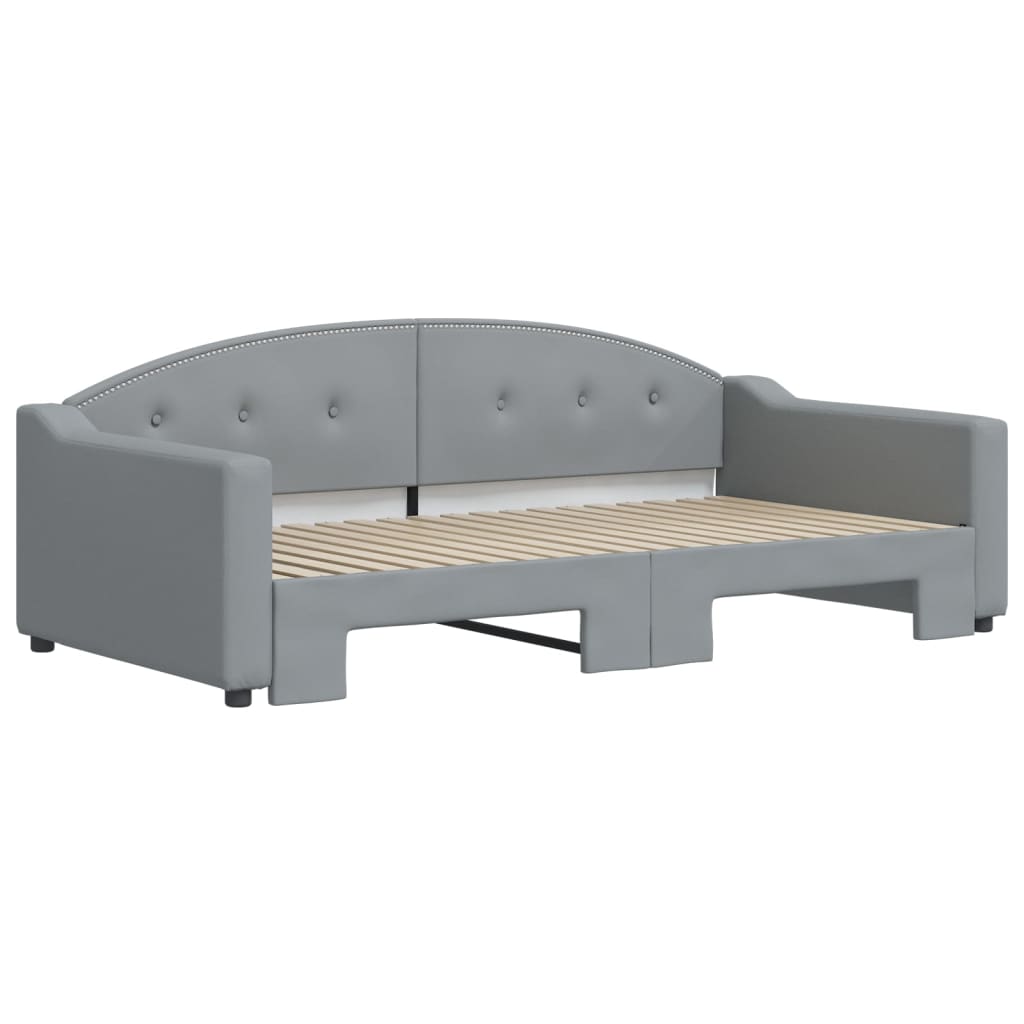 Gray upholstered daybed with pullout trundle and tufted headboard