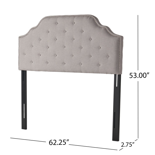 Light grey upholstered headboard with button tufting and nailhead trim