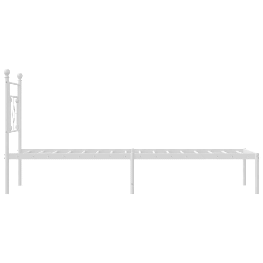 White metal twin bed frame with upholstered mattress and patterned bedding