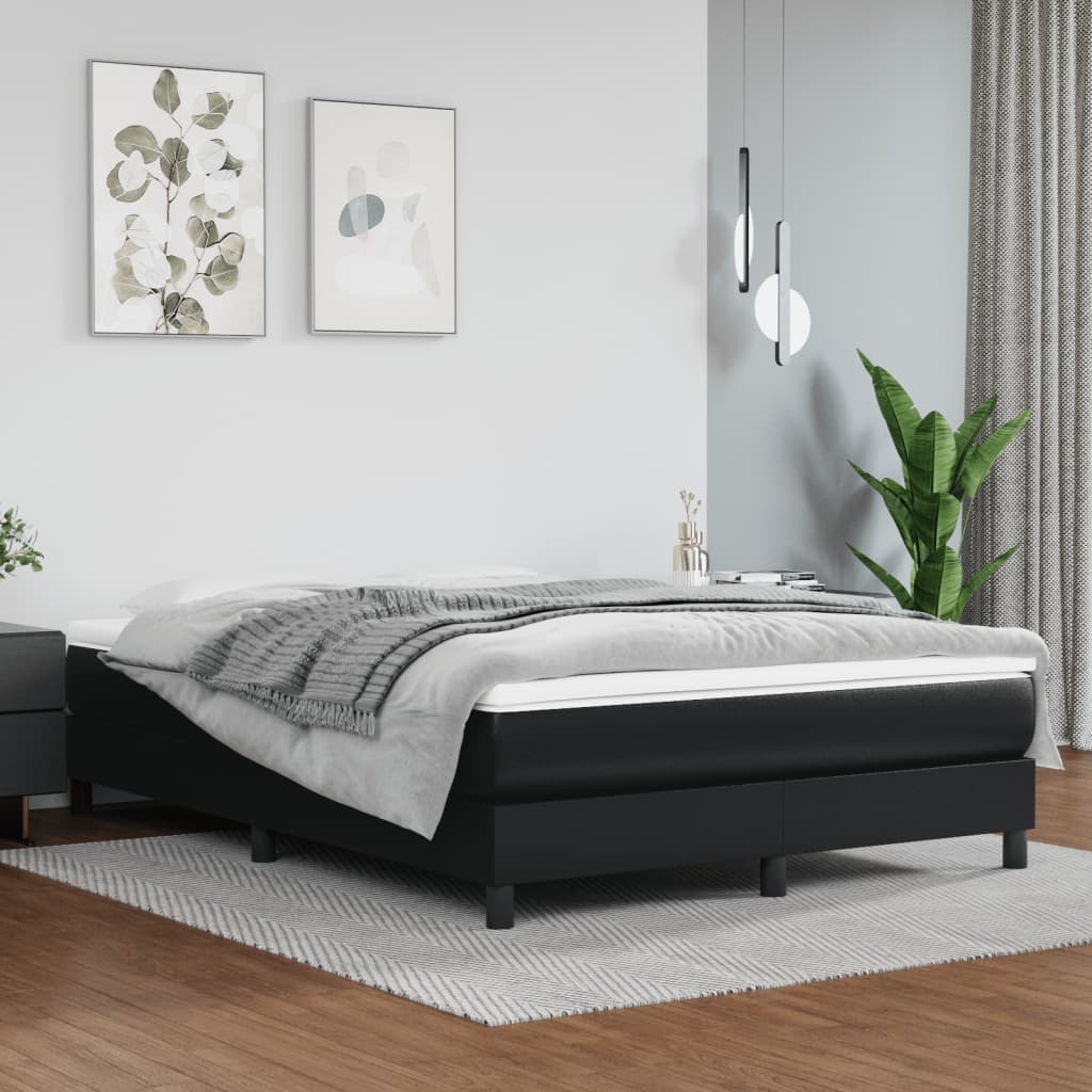 Modern black faux leather bed frame with a plush mattress and grey throw blanket