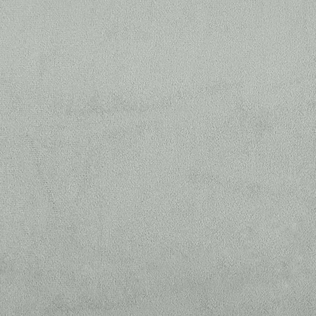 Closeup of a light grey upholstered bed frame with a dark cylindrical bed leg
