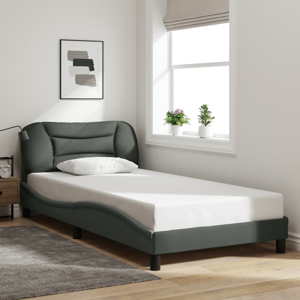 Modern upholstered twin bed in dark gray with curved frame and plush headboard