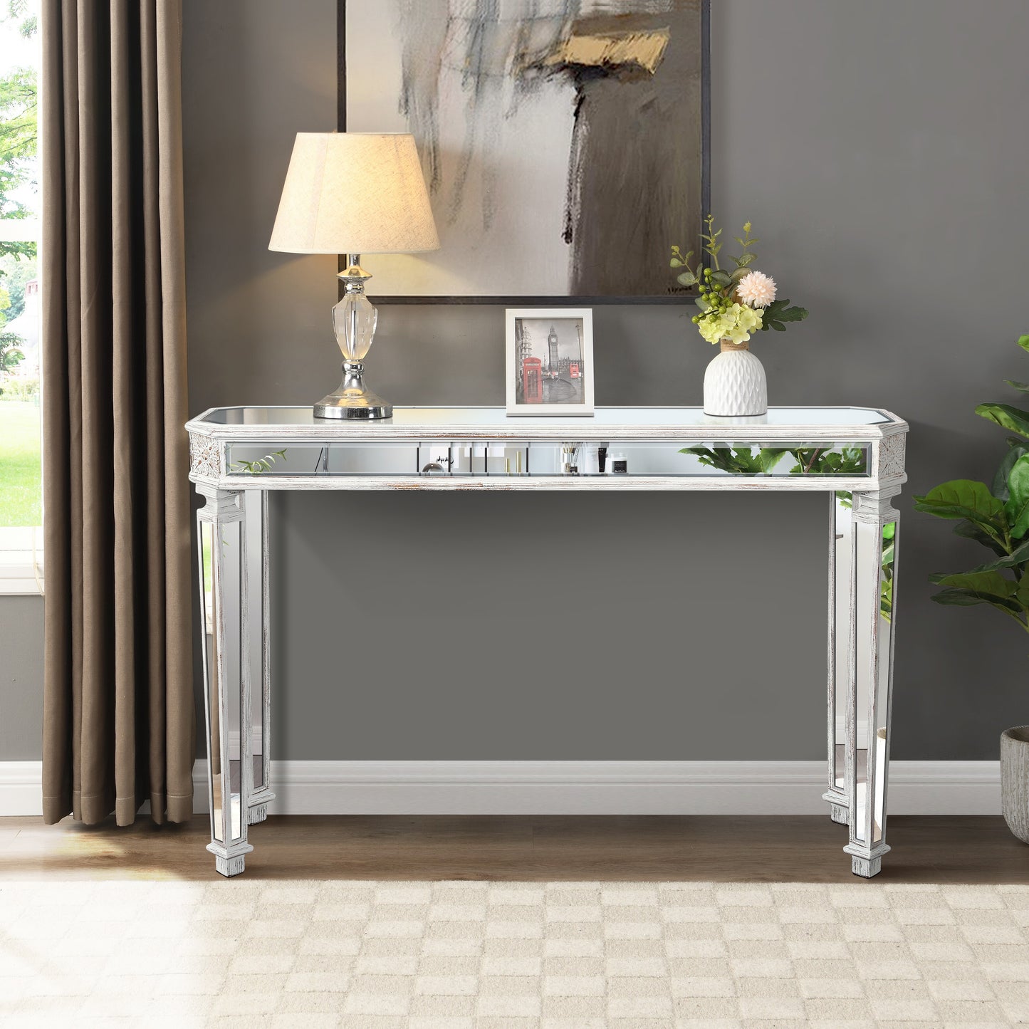 White mirrored console table with decorative carvings and glass top