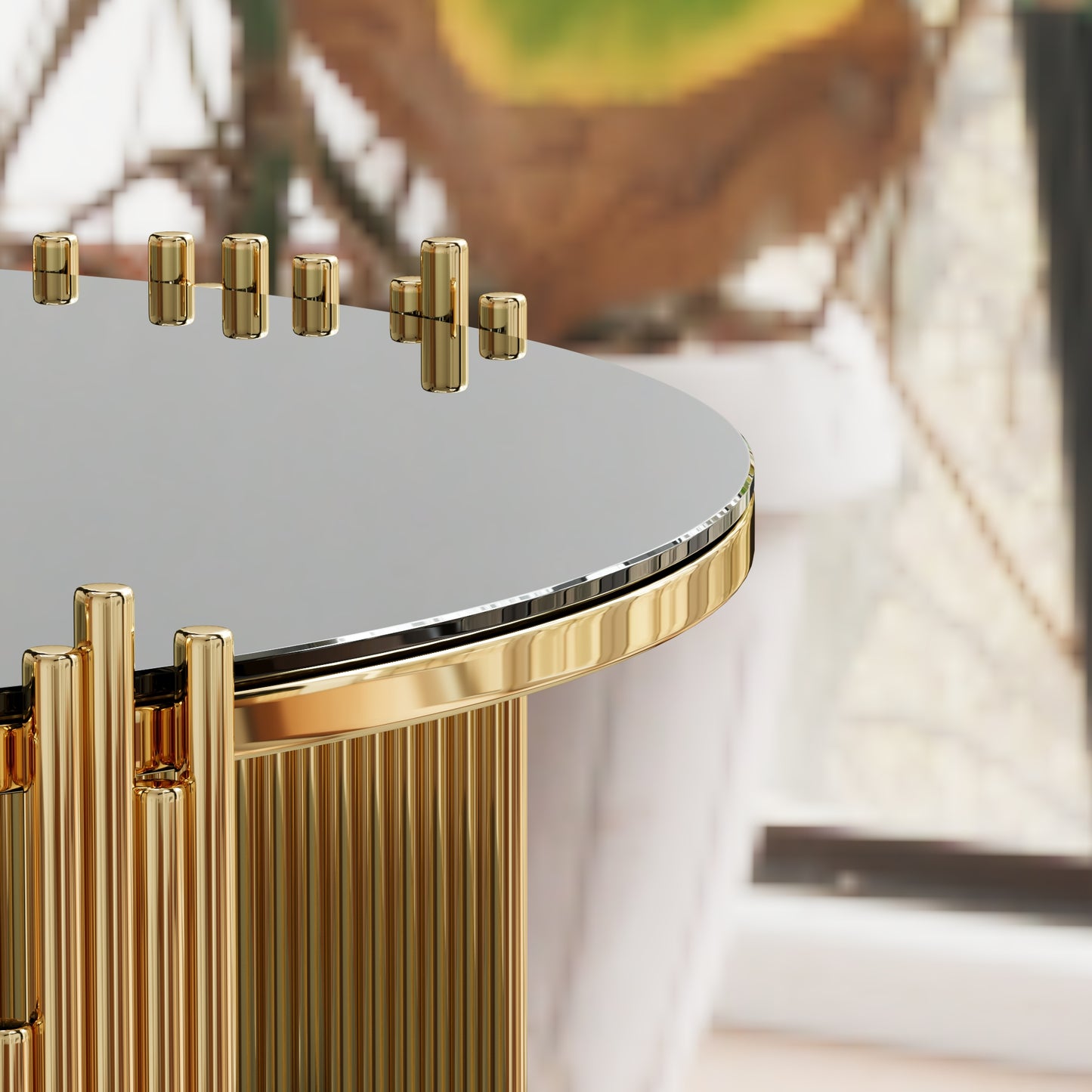 Round glass coffee table with fluted gold base and cylindrical accents
