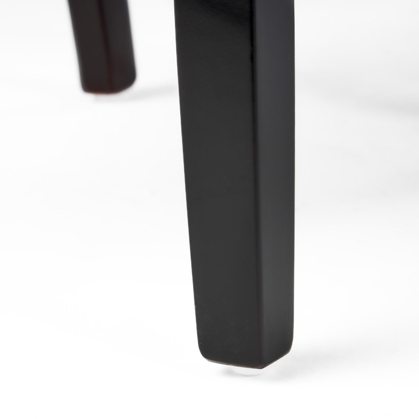Dark wood chair leg with clear floor protector on white background