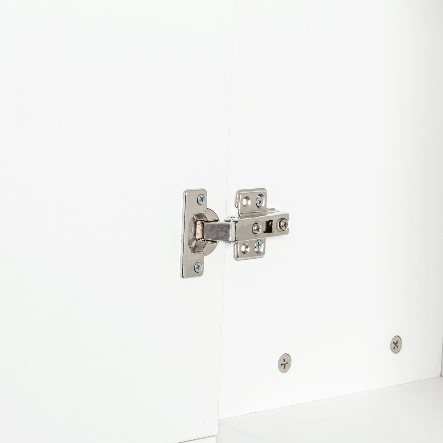 Closeup of silver concealed cabinet hinge on white surface