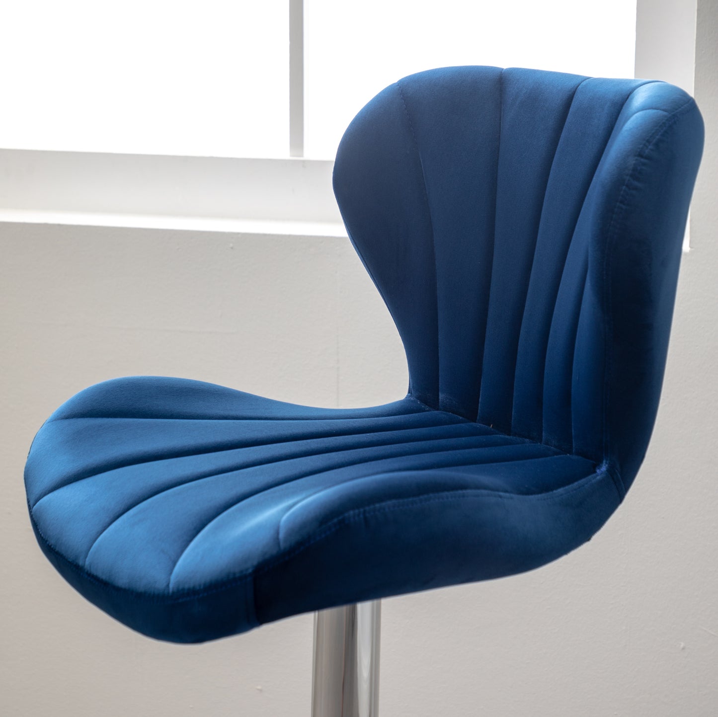 Deep blue velvet bar stool with channel tufting and ergonomic seat