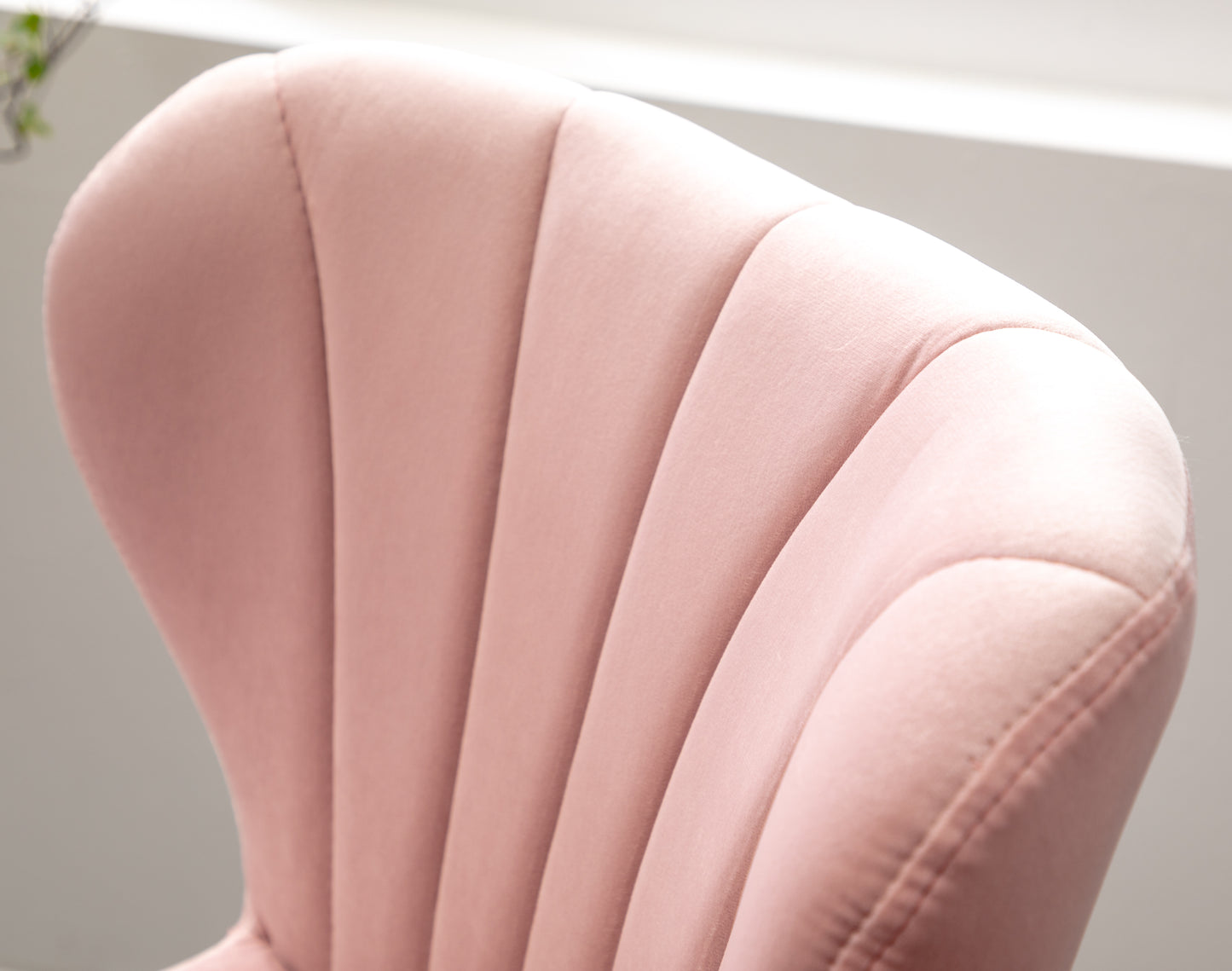 Closeup of plush pink velvet accent chair with channel tufting