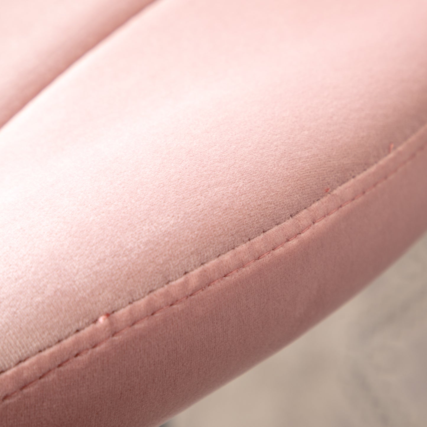 Closeup of plush pink velvet fabric texture with detailed stitching