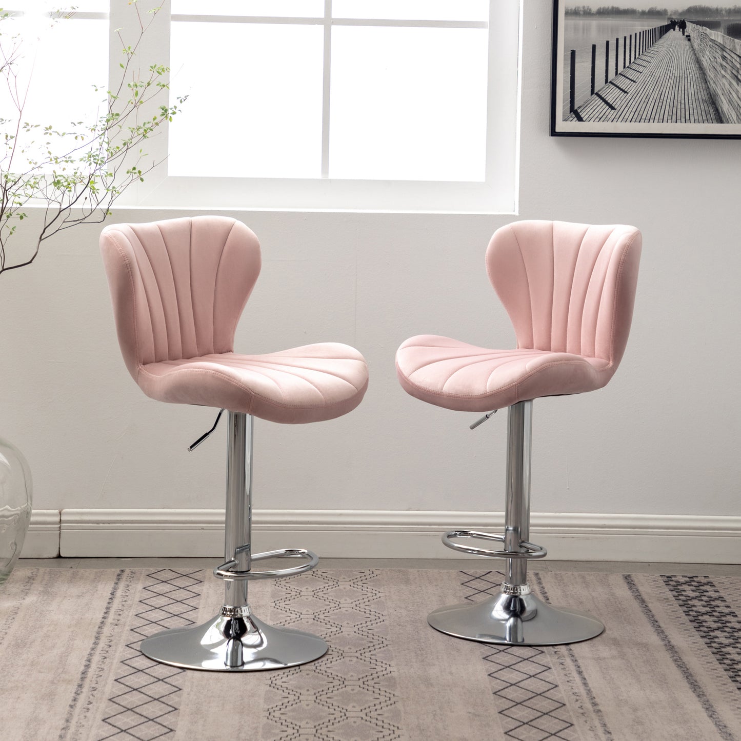 Set of two plush pink velvet bar stools with adjustable height and chrome base