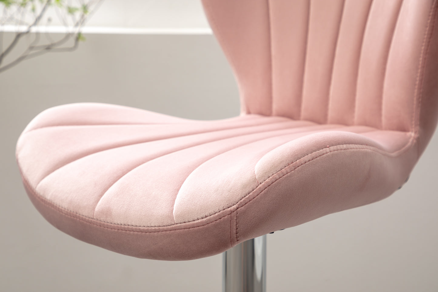 Closeup of a plush pink velvet accent chair seat with channel tufting
