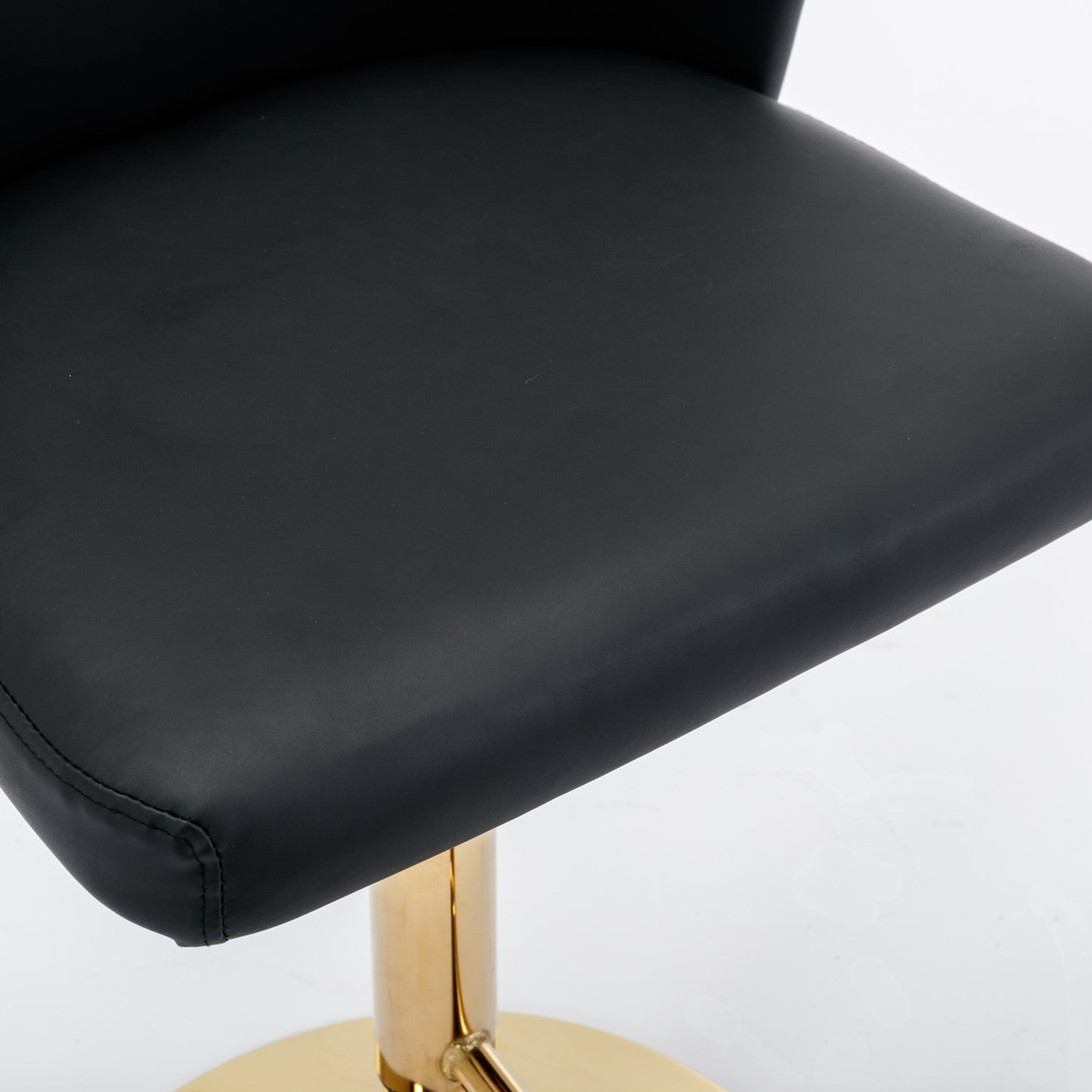Black faux leather bar stool seat with gold pedestal base