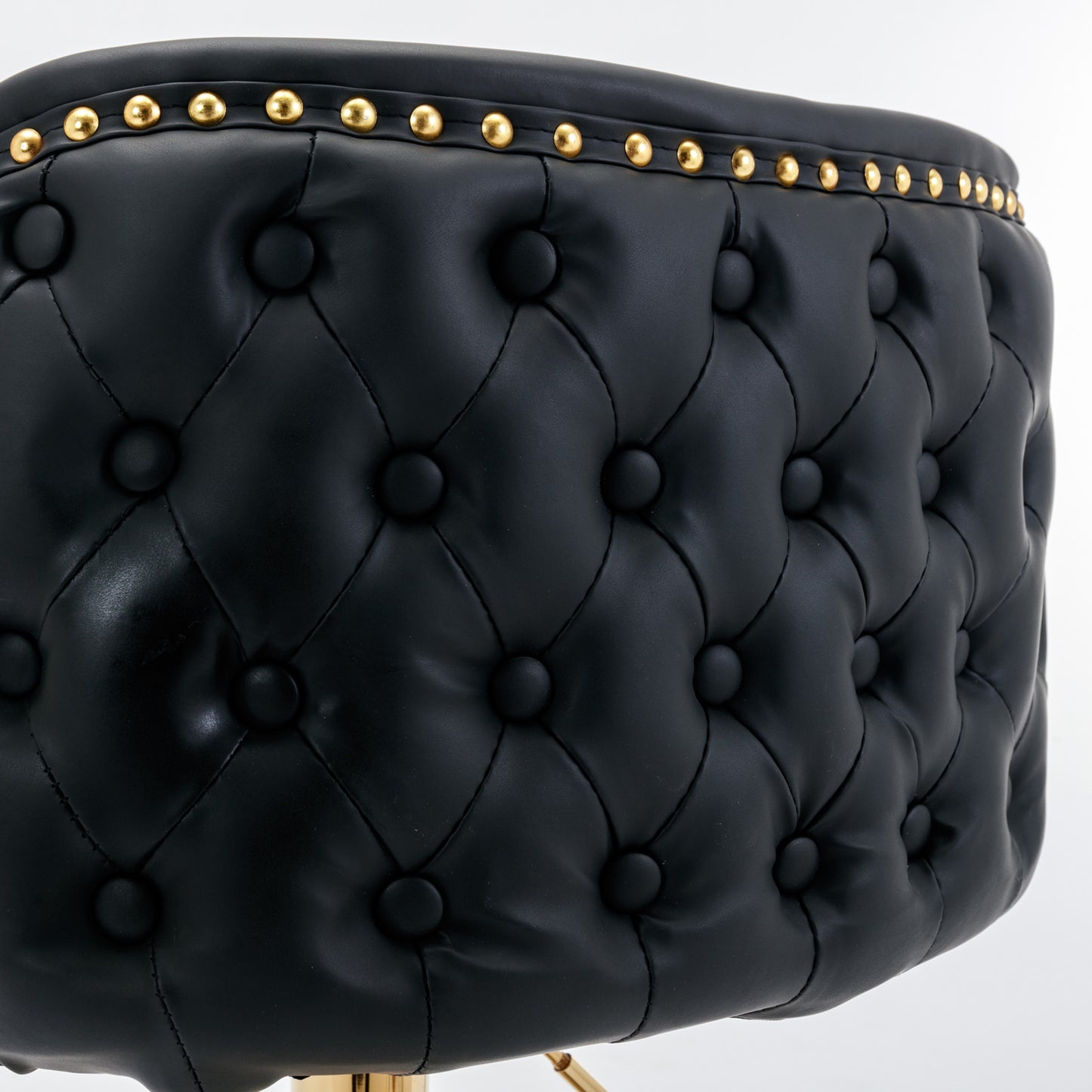 Tufted black faux leather stool seat with gold nailhead trim detail
